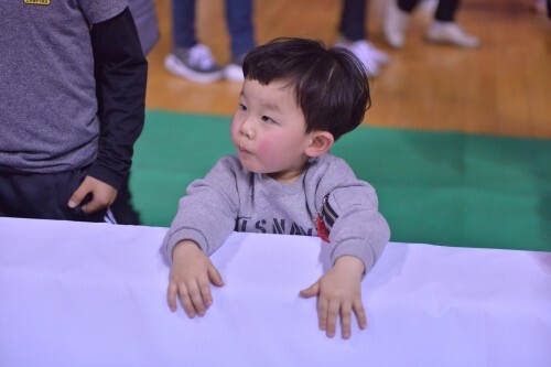 경기가 끝난 후 선수들을 신기하게 쳐다보고 있는 꼬마 관중.